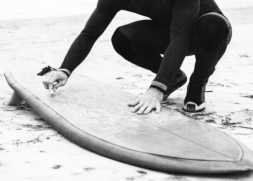 Arte desportiva: surfista a preparar a prancha