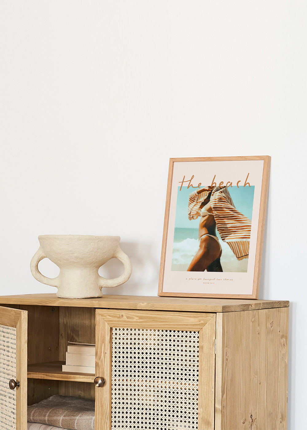 Quadro paisagem com figura na praia e toalha às riscas
