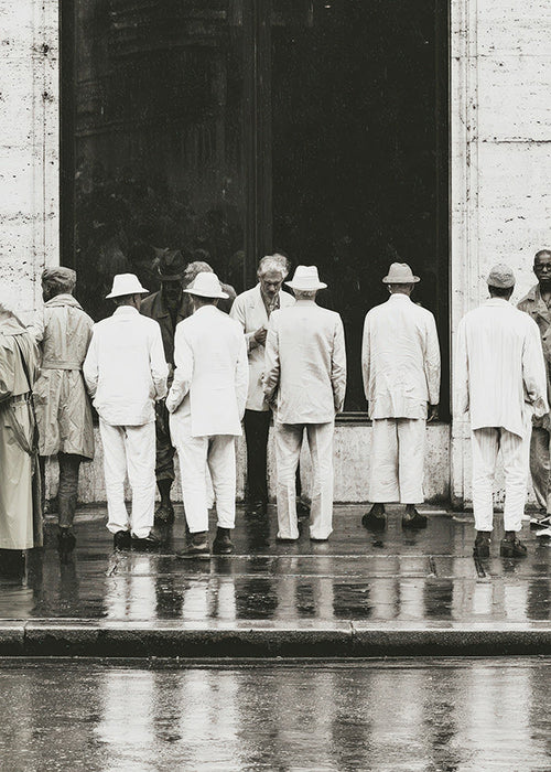 Fotografia a preto e branco de homens de costas na chuva