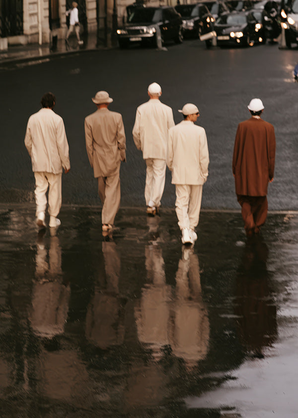 Fotografia urbana: cinco figuras a andar na rua molhada